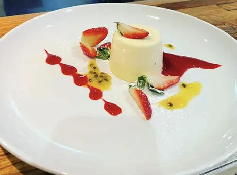 Vanilla panna cotta with strawberry, berry coulis, passionfruit and mint
